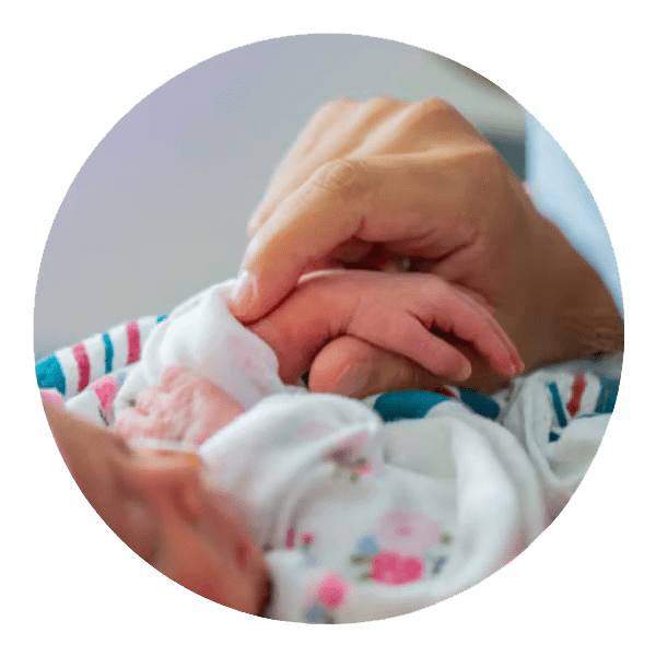 close up of mom's hand holding newborn hand